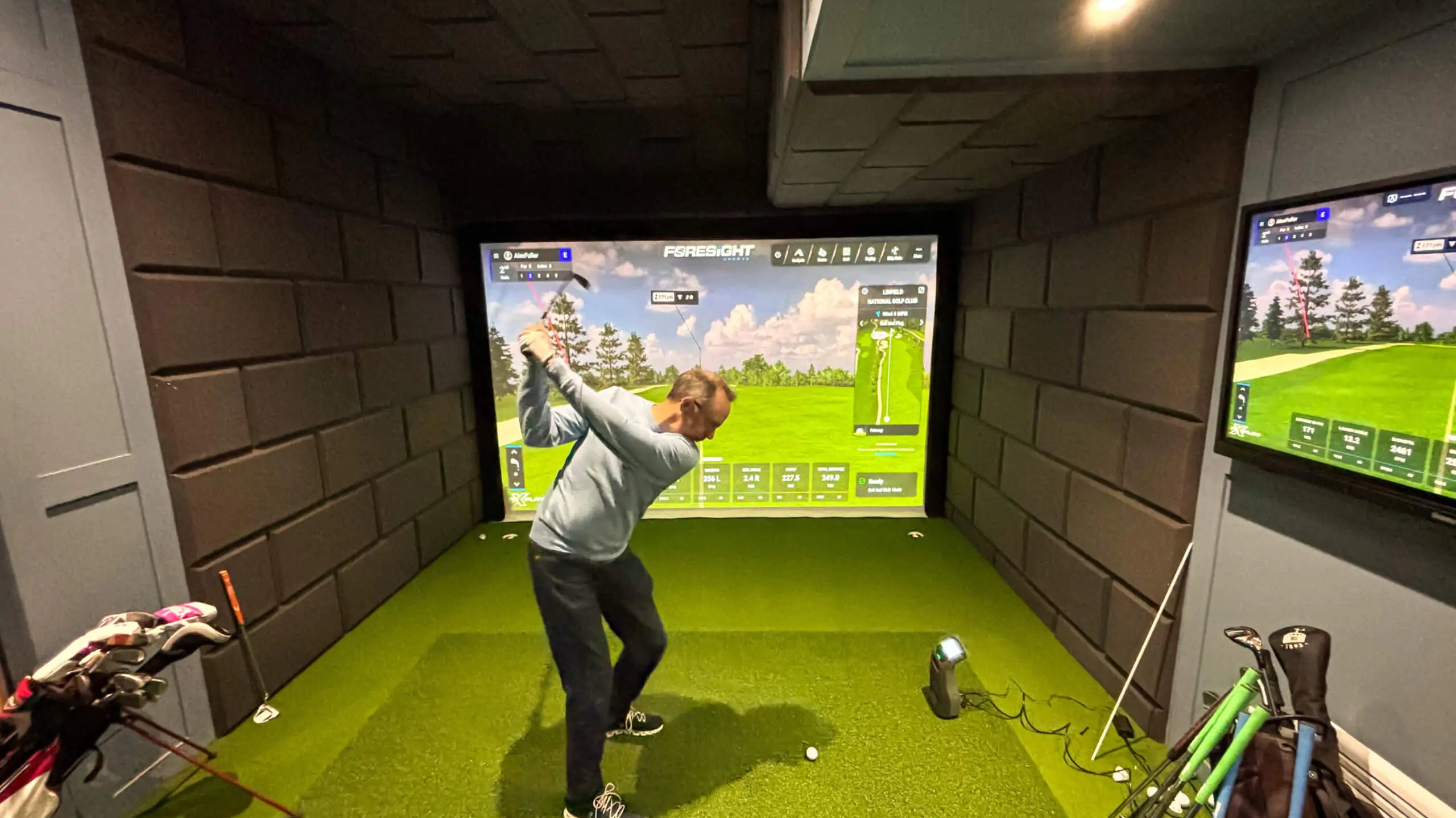 the best golf simulators rear view with golfer swinging