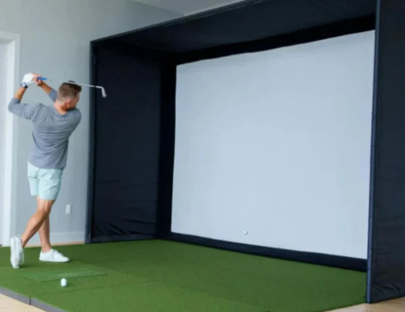 golf simulator enclosure and impact screen with golfer hitting into screen at angle