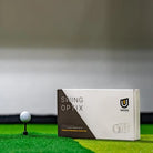 uneekor swing optix cameras box shot on top of hitting mat next to tee with ball